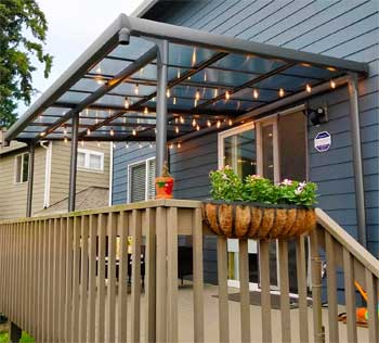 Retractable Polycarbonate Pergola Attached to Wall of House, with Hanging String Lights